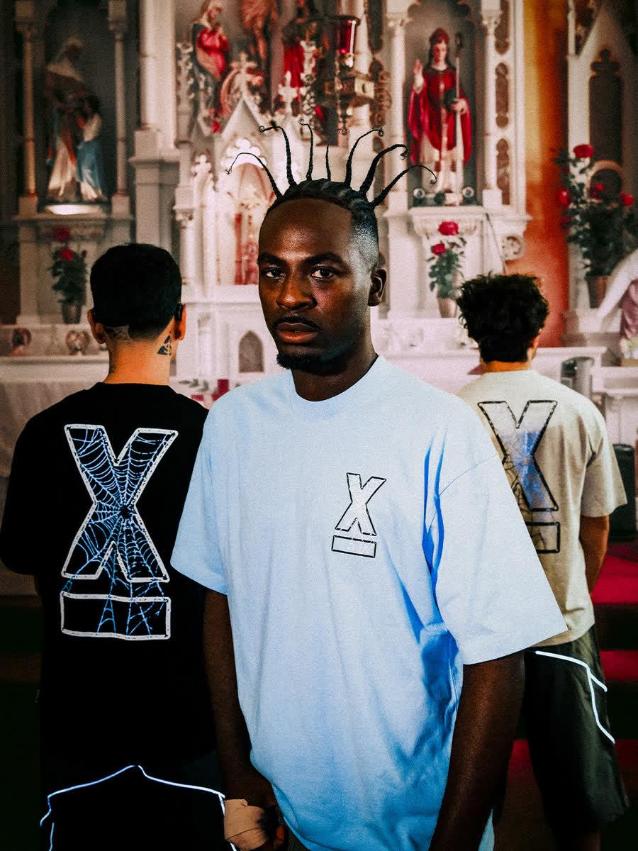 Model in a pale blue StreetX tee, with two others wearing X-print tees behind him, from the StreetX Europa collection campaign